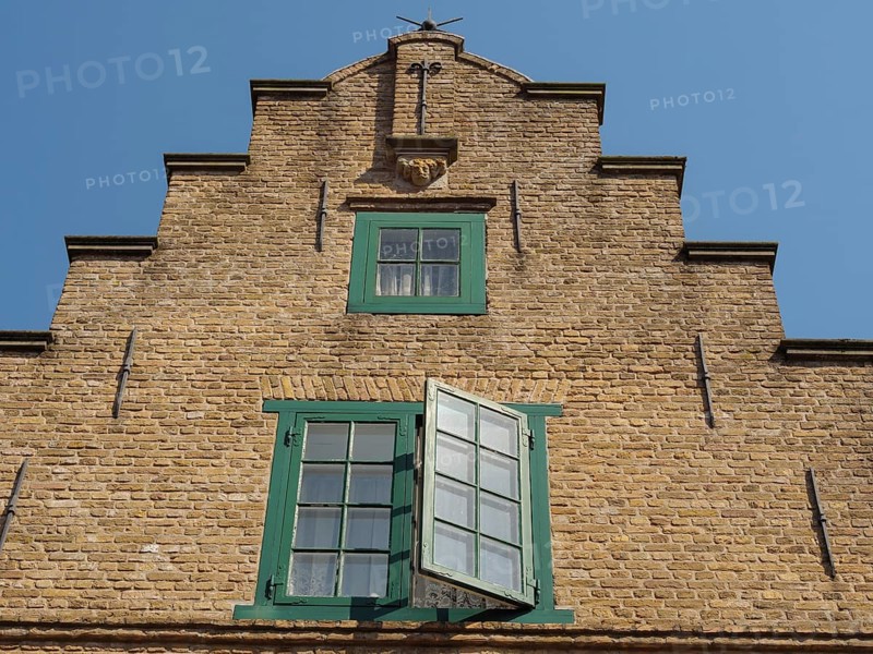 Historic brick building with green framed windows and blue sky, friedrichstadt, schleswig-holstein, germany
