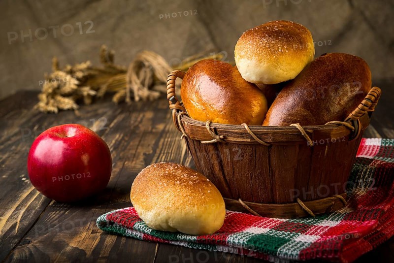 Baked apple pies in basket on wooden table