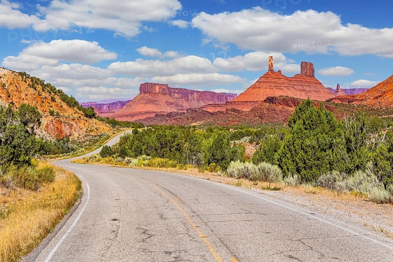 The reds and browns of Utah's vibrant landscapes. Wide asphalt highway among picturesque hills and rocks of bizarre shapes. US. Utah Red Sandstones