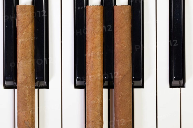 Detail of piano keyboard and luxury cigars