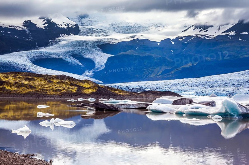 The grand glacier Vatnajokull is melting at the edges, sliding to the ocean. Glacier meltwater form a picturesque lake. Summer in Iceland. The concept of extreme northern tourism