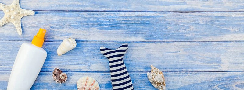 Long wide banner flat lay concept summer travel vacations. Top view of sunscreen bottle mockup seashells and starfish pastel blue wooden planks background copy space rustic style frame template text