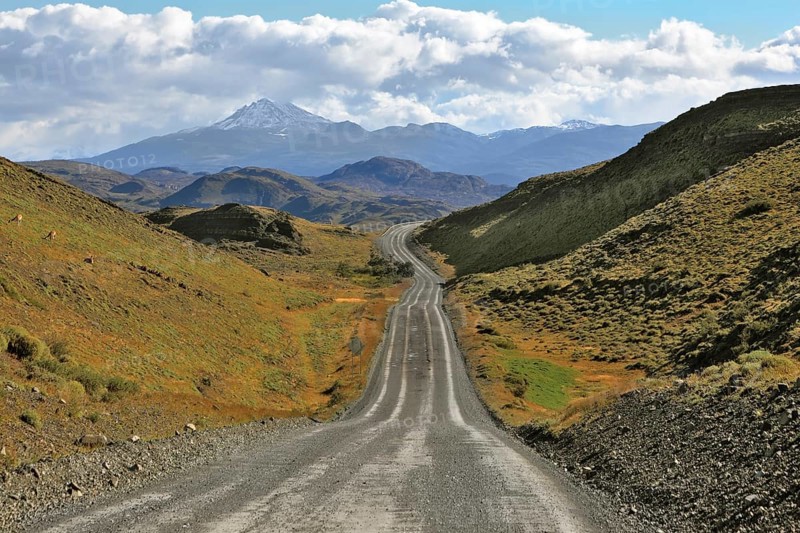 A gravel road winds among the hills and mountains. Chilean Patagonia. Summer in the national park Torres del Paine