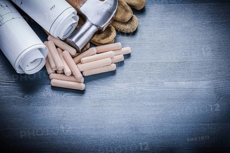Rolled blueprints hammer gloves wooden dowels