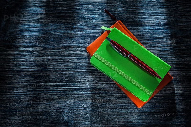 Office notebooks pen on wooden board