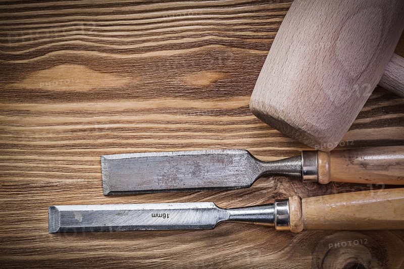 Wooden mallet chisels on vintage wood board construction concept