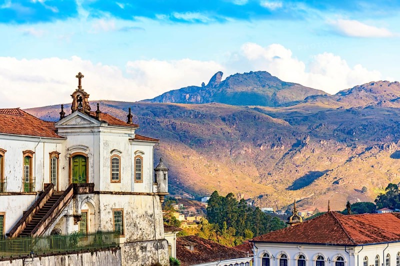 Baroque church and mountains in the city of Ouro Preto in Minas Gerais with the mountains and peak of Itacolomi in the background during sunset