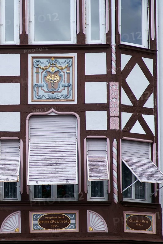 An old listed residential and commercial building of a former pharmacy with the coat of arms of the Hermes staff