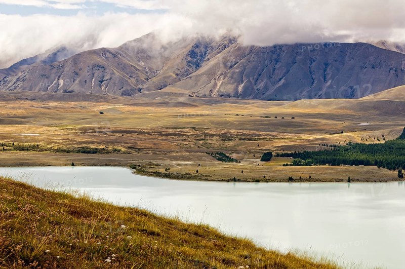 Lake Tekapo and the surrounding hills under clouds, South Island, New Zealand