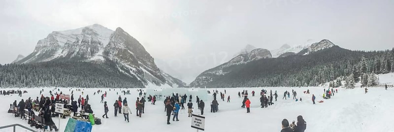 Lake Louise, Alberta, Canada. Jan 29, 2024. A panoramic scene capturing individuals engaged in ice skating on the frozen expanse of Lake Louise, framed by the majestic backdrop of the mountains