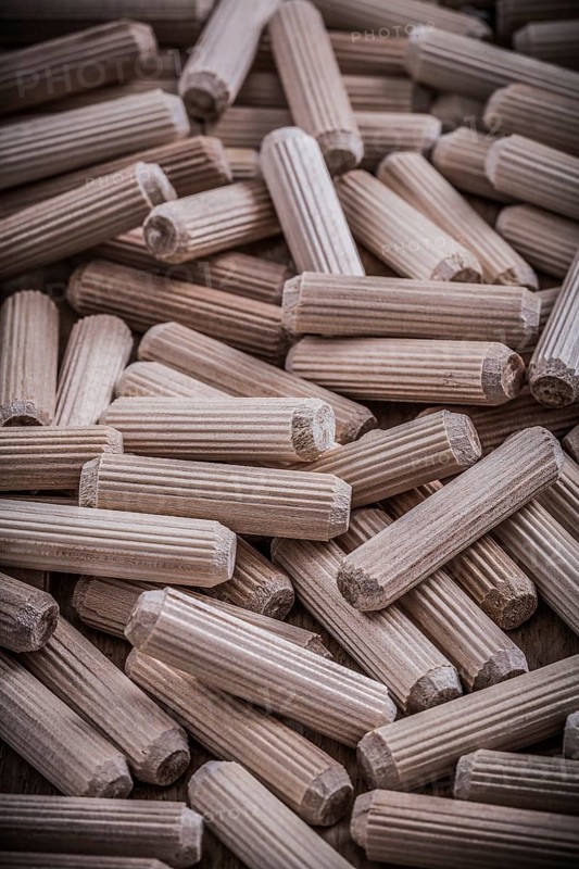 Collection of woodworking dowels on wooden board construction concept