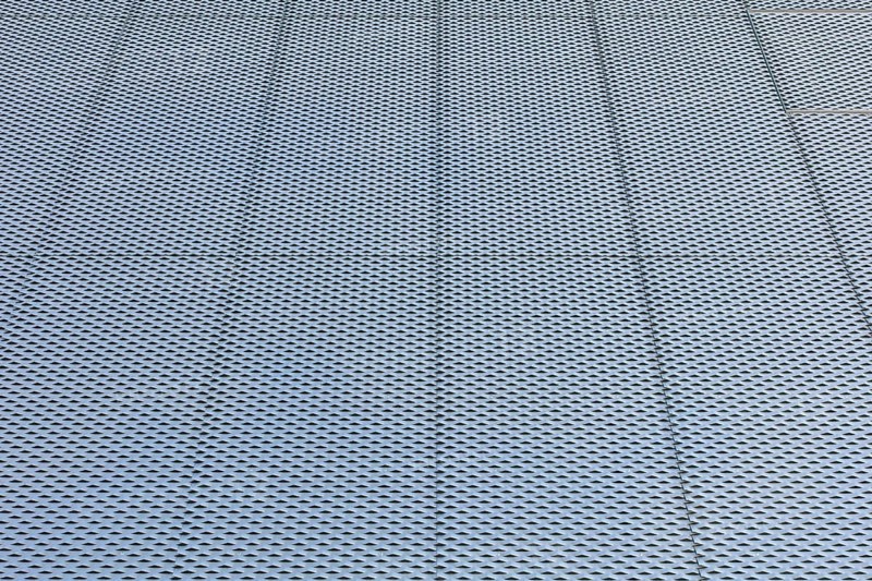 Closeup of metal mesh on concrete wall background texture
