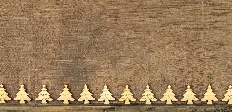 Christmas decoration wooden background with row of small wooden fir trees