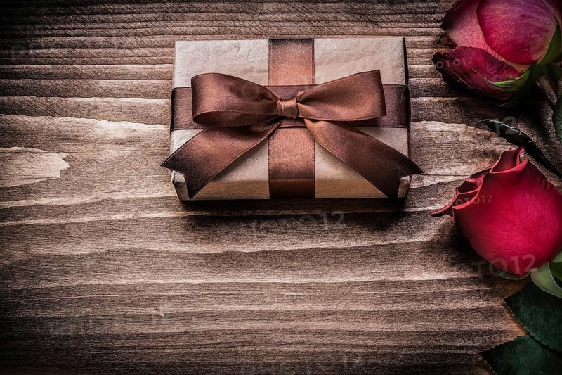 Red natural roses present box on wooden board holidays concept