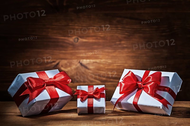 Giftboxes with red ribbons on vintage wood