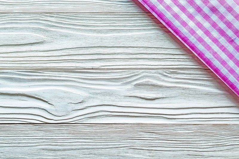 Pink checked towel on wooden board copy space