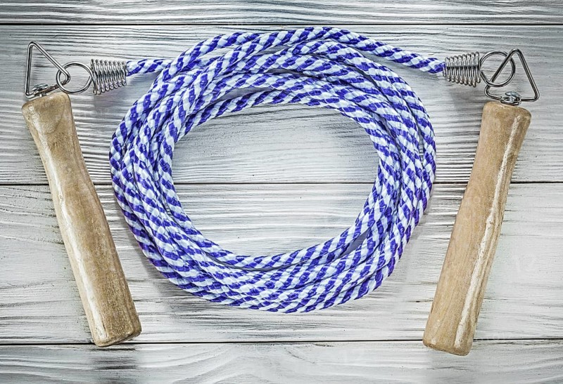 Rolled skipping rope on wooden board sports training concept