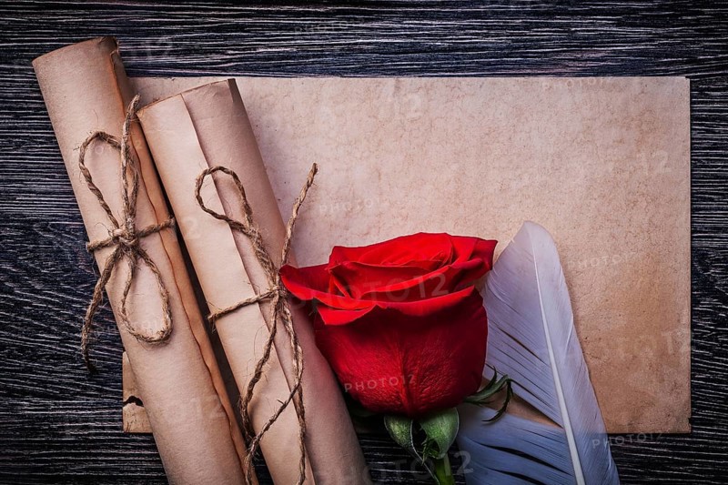 Vintage paper rolls red natural rose on wooden background