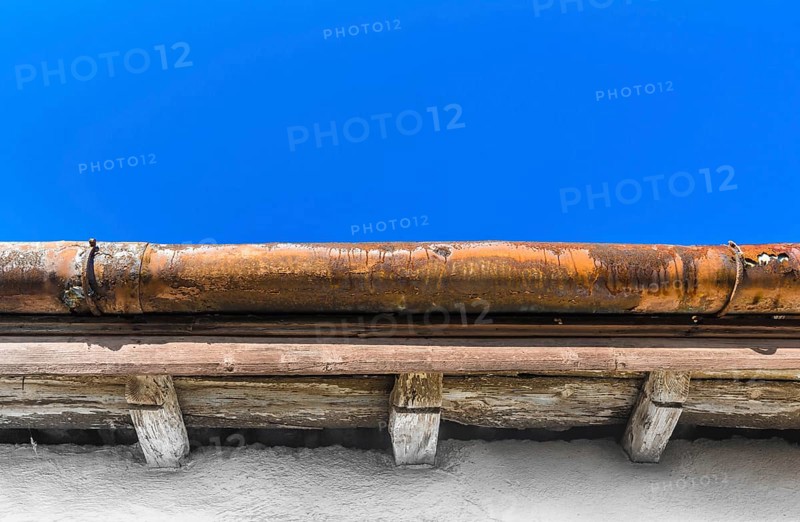 A broken gutter on the roof of a house