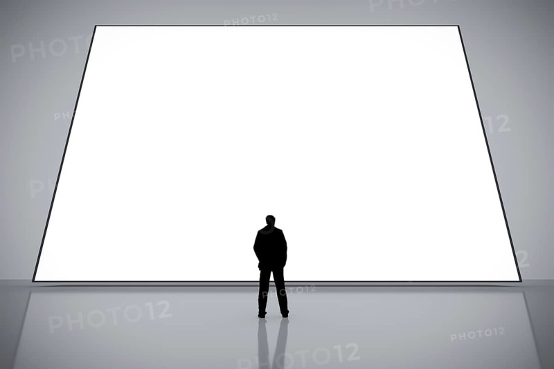 A man in front of a big white empty screen