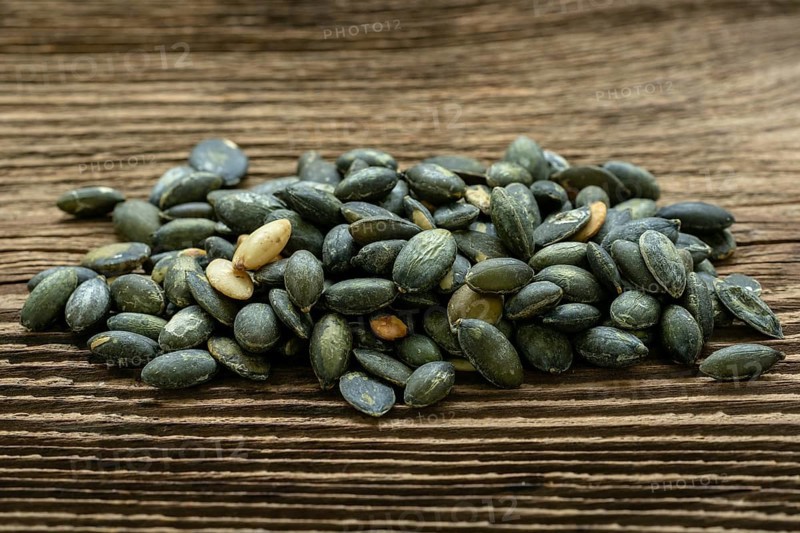 Pumpkin seeds seasoned using sea salt. Pumpkin seeds over wooden table