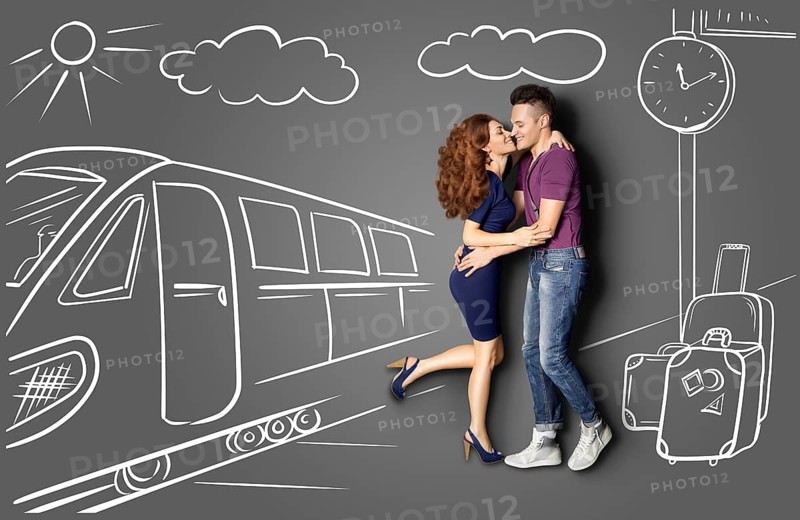 Happy Valentine's Day love story concept of a romantic couple against chalk drawings background of a railway station. Male meets his girlfriend at the station and kisses her under a street clock