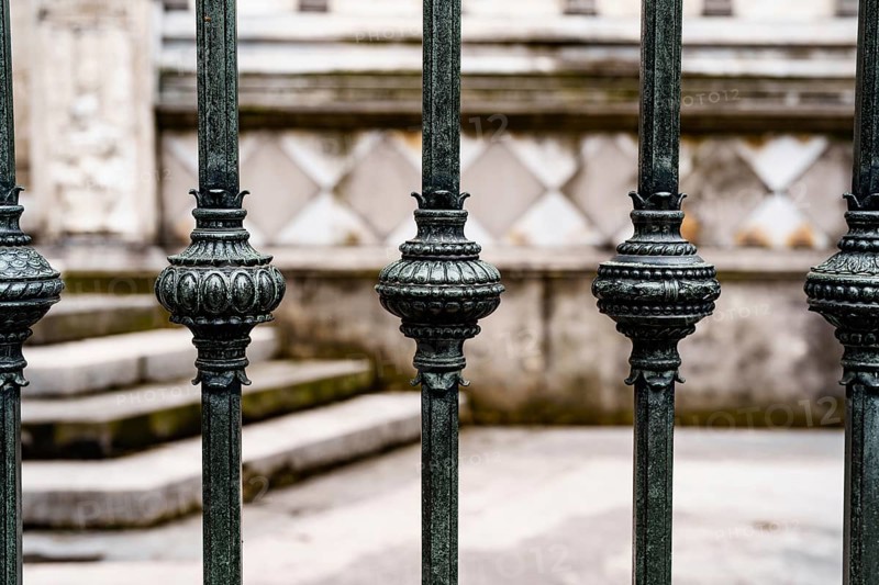 Antique wrought iron fence with decorative spherical inserts.