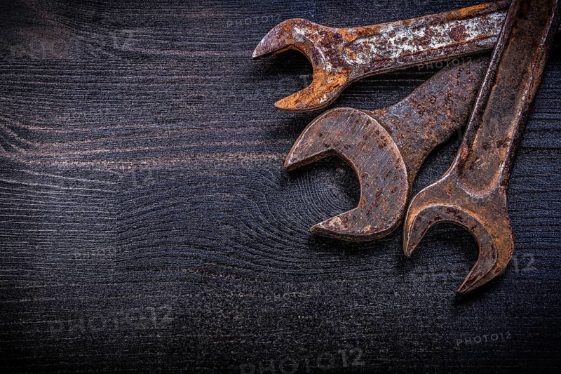 Vintage grunge open-end wrenches on wood board construction concept