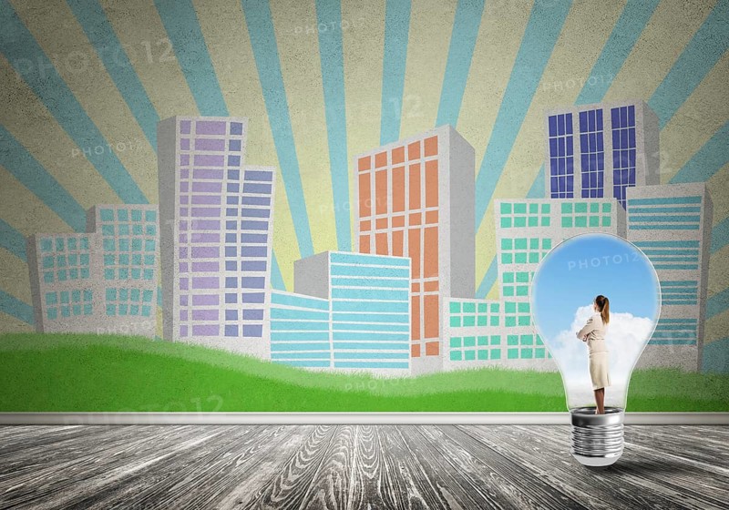 Businesswoman inside light bulb against city drawn concept