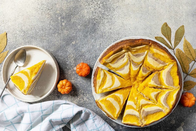 Healthy autumn dessert for breakfast. Pumpkin cottage cheese casserole pie Zebra, striped casserole with cheese, chocolate and pumpkin on stone background. View from above. Copy space