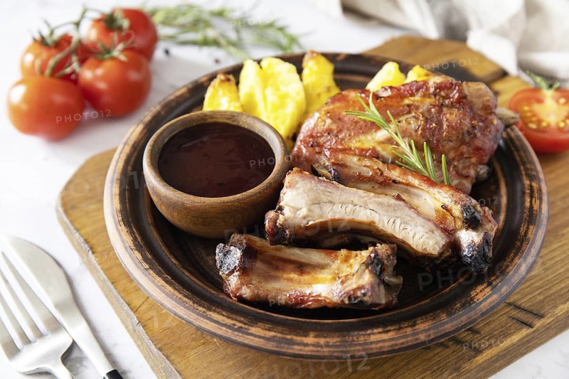BBQ grilled veal calf brisket meat and french fries potatoes with sauce on a marble tabletop