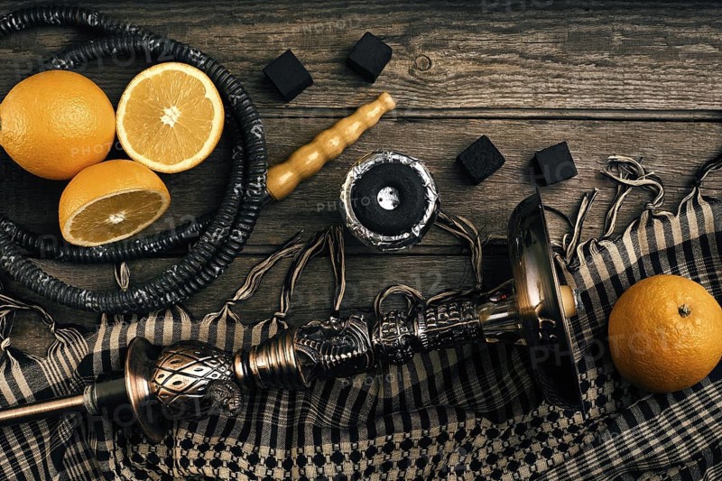 Dismantled parts of hookah on a wooden background with orange fruit. Top view. Flat lay. Copy space. Still life