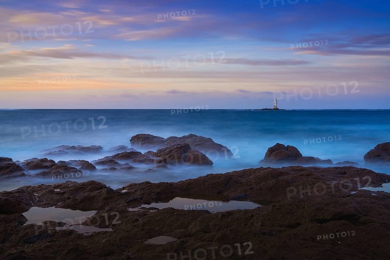 Long exposure view of the Sant'Antioco island coast and the Mangiabarche Lighthosue at sunrise on Sardinia