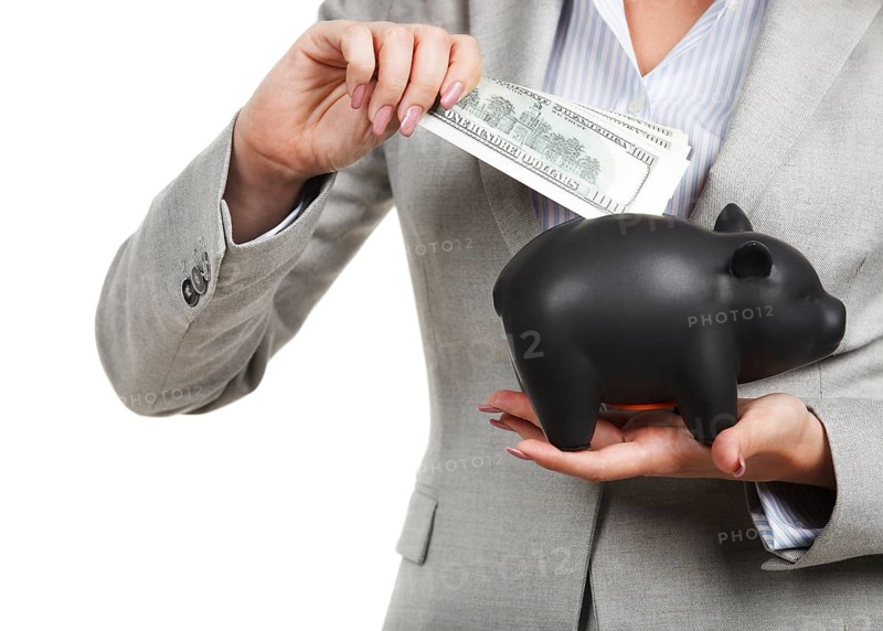 Businesswoman holding the piggy bank and dollar bills in her hands