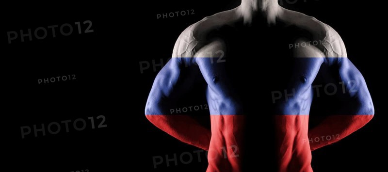 Russia flag on muscled male torso with abs, black background