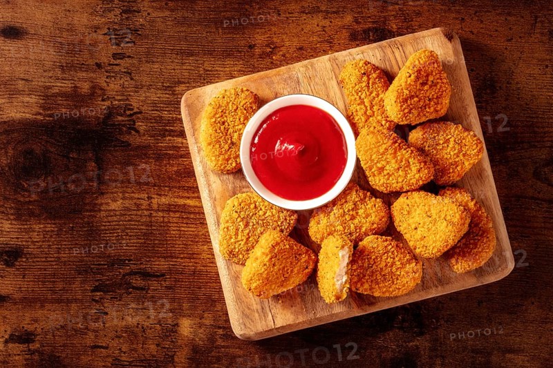 Chicken nuggets with ketchup on a rustic wooden table, shot from the top with a place for text. Crispy snack, Food photography, Food photography