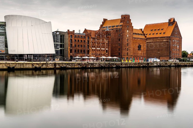 Stralsund, Germany, August 1, 2019: Scenic view of the harbour and the Ozeaneum aquarium in Stralsund. Long exposure view at sunrise with reflection on water