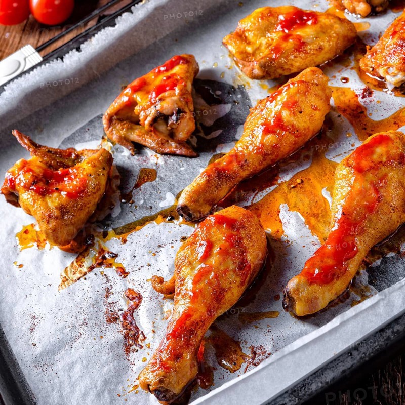 Rustic backed chicken wings, legs on baking tray
