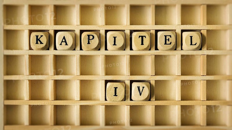 An image of a wooden game with the word chapter four in german language