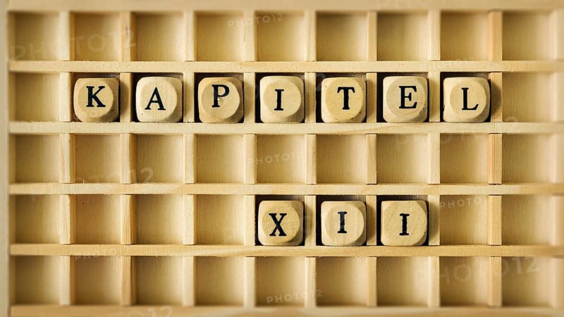 An image of a wooden game with the word chapter twelve in german language