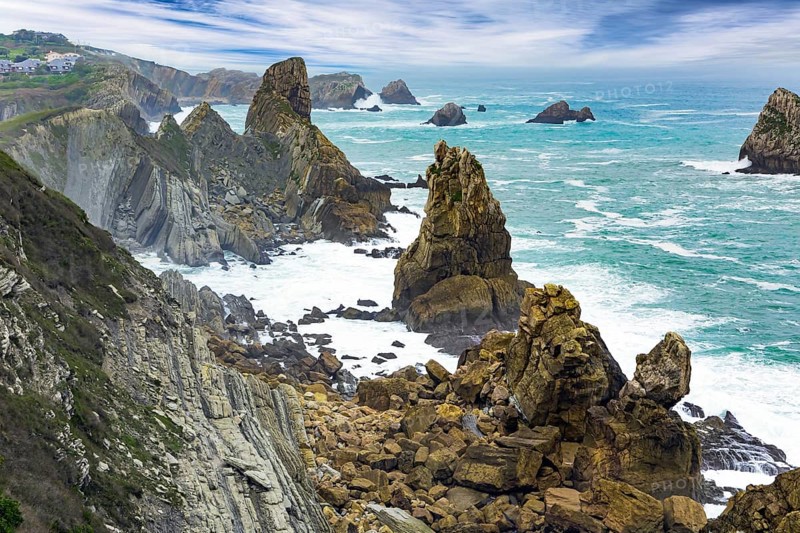 Noon on the beach of Playa di Arnia, Spain. Cantabria. Windy stormy day on the Atlantic coast. Rocky picturesque ocean coast