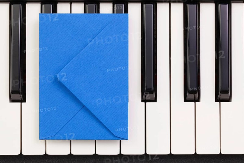 Funny arrangement envelope on the piano keybords - Flat lay image