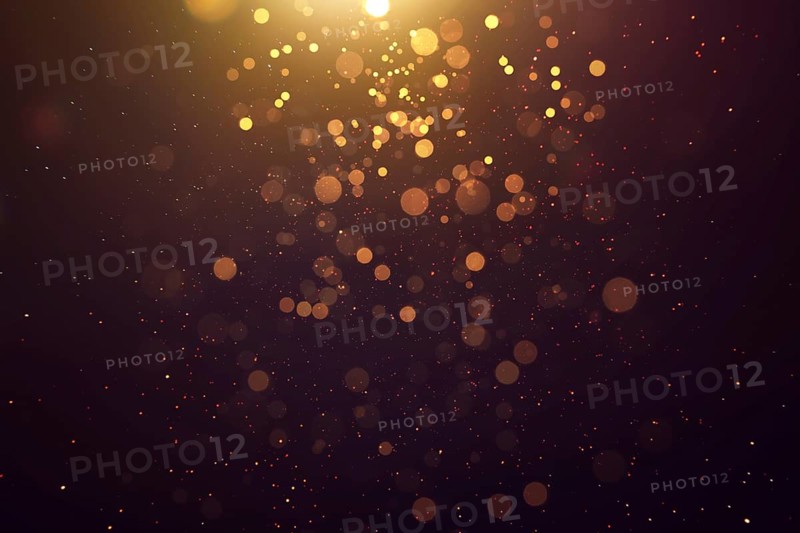 Abstract glittering gold with bokeh and dust effect . Black background