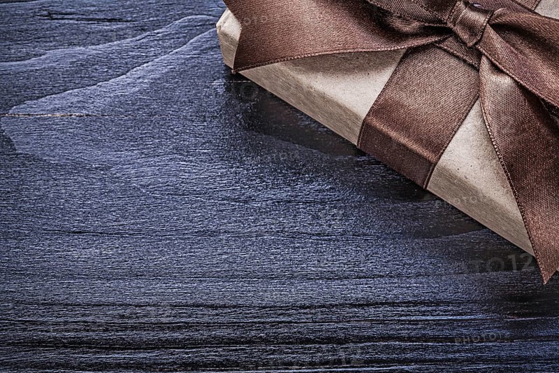 Gift box wrapped in recycled paper on wooden board