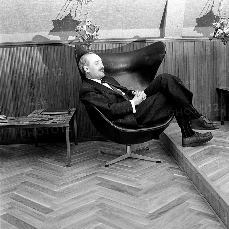 Simon Ove Christian Ogilvie Spies (1 September 1921 – 16 April 1984) was a Danish tycoon, best known for founding the charter airline Spies Rejser, and its airway company Conair of Scandinavia, and for his flamboyant lifestyle and womanising, including the procurement of sexual services from young women, the morgenbolledamer. Photographed sitting in an Egg armchair, designed by Arne Jacobsen for the Royal Hotel in Copenhagen. In 1958, the egg armchair became an instant success and has reached iconic status that is hard to beat. Egg armchairs were created using a technique that Jacobsen was the first to use. A durable inner shell of foam under the padding. 1961