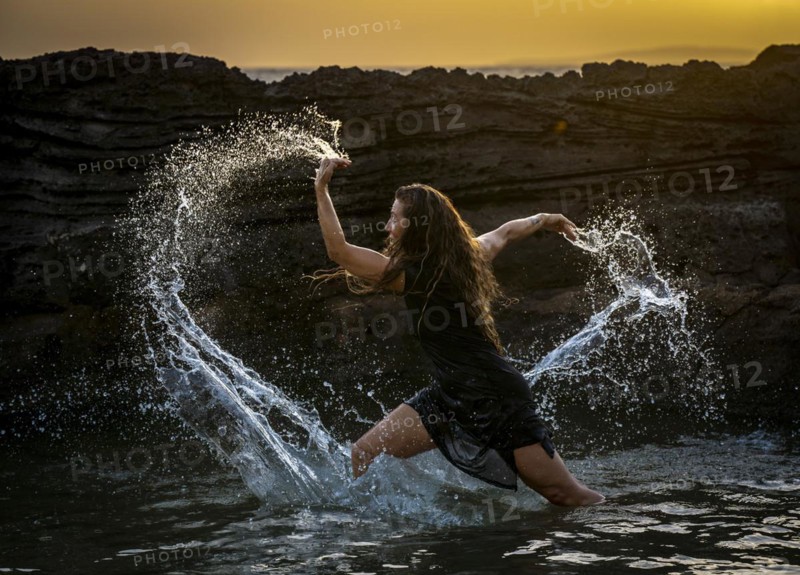 Middle-aged woman dancing and throwing water in the air, Maioris beach, llucmajor, Majorca, Balearic Islands, Spain