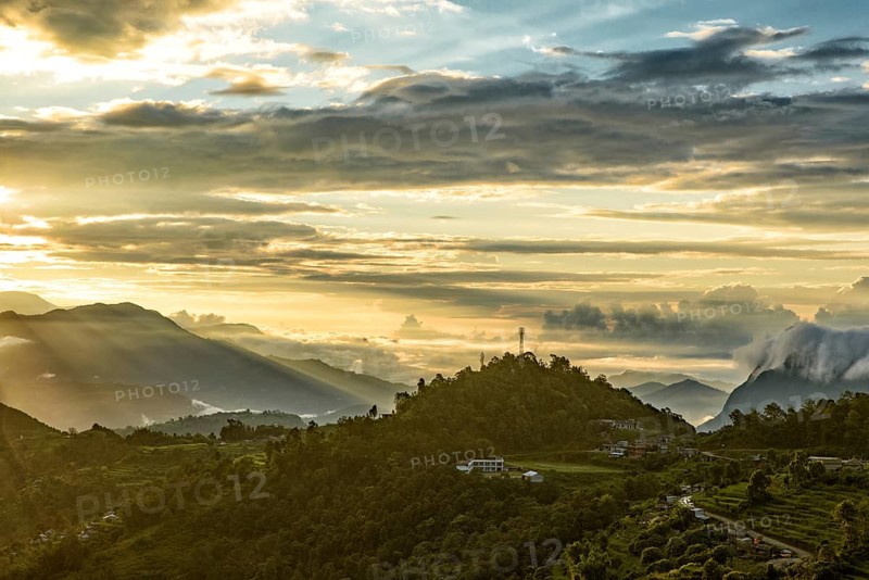Mountains under the light of sunrise through clouds