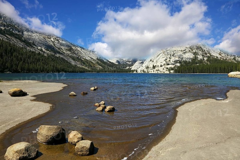 Flat coast of shallow lake in mountains of national park Yosemite