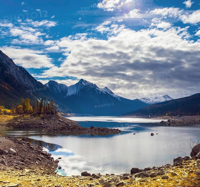 Canada, Alberta, Jasper Park. Lake Medicine. Great autumn day. The sun illuminates the snow-capped mountains. The concept of active, ecological and photo tourism