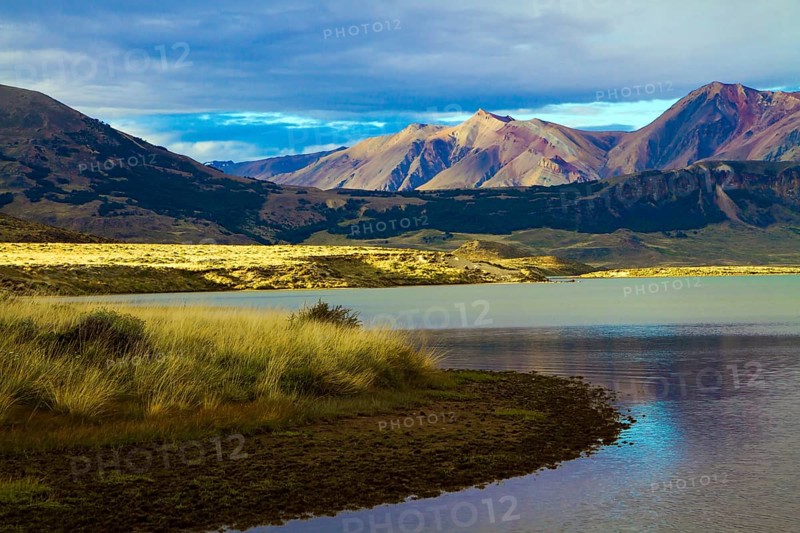 Huge lake with azure water, arid steppe of Patagonia and the steep slopes of cold mountains. Los Glaciares Natural Park in Argentina. The concept of active, extreme and photo tourism